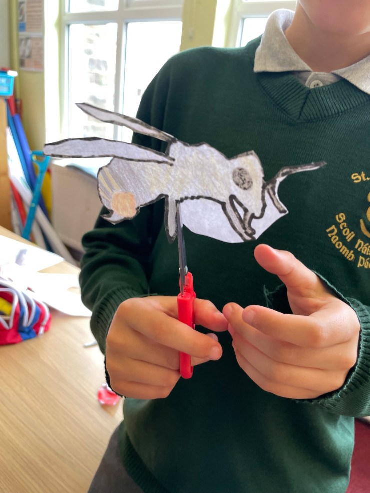 a photo of a child cutting out a drawing of a bee